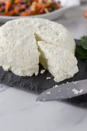 A photo of fresh homemade queso fresco on a slate cheese board.