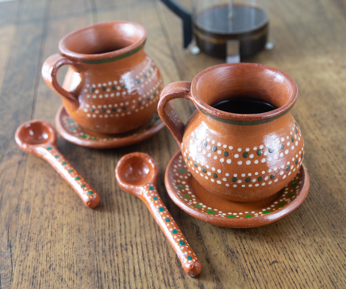 A photo of Mexican style coffee cups, saucers and spoons for serving cafe de olla.