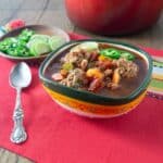 A photo of Mexican albondigas in a green and yellow bowl.