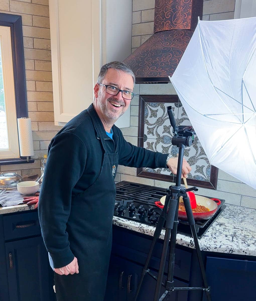 Tom Braeger in studio kitchen taking step by step photos of a recipe.
