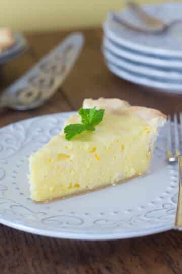A photo of orange and lemon chiffon pie on a white plate with a fork.